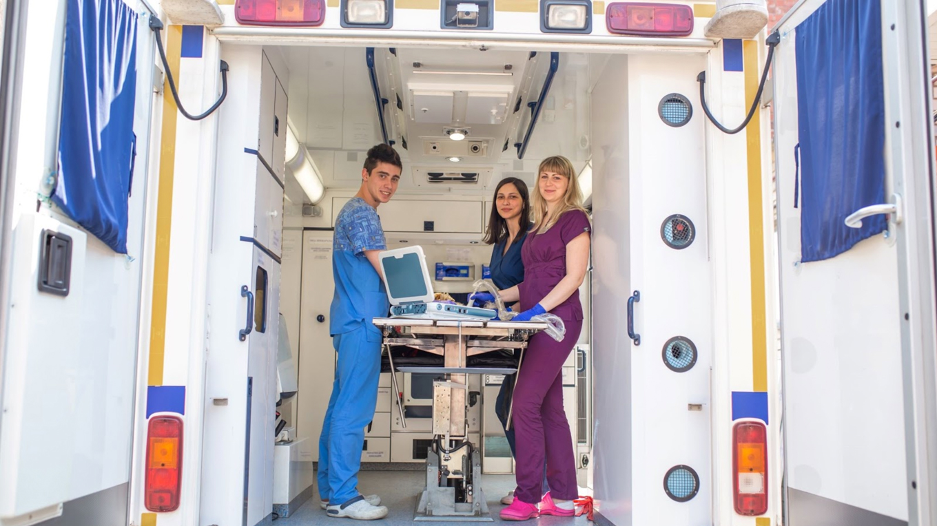 Team using point-of-care ultrasound EMS equipment in an ambulance